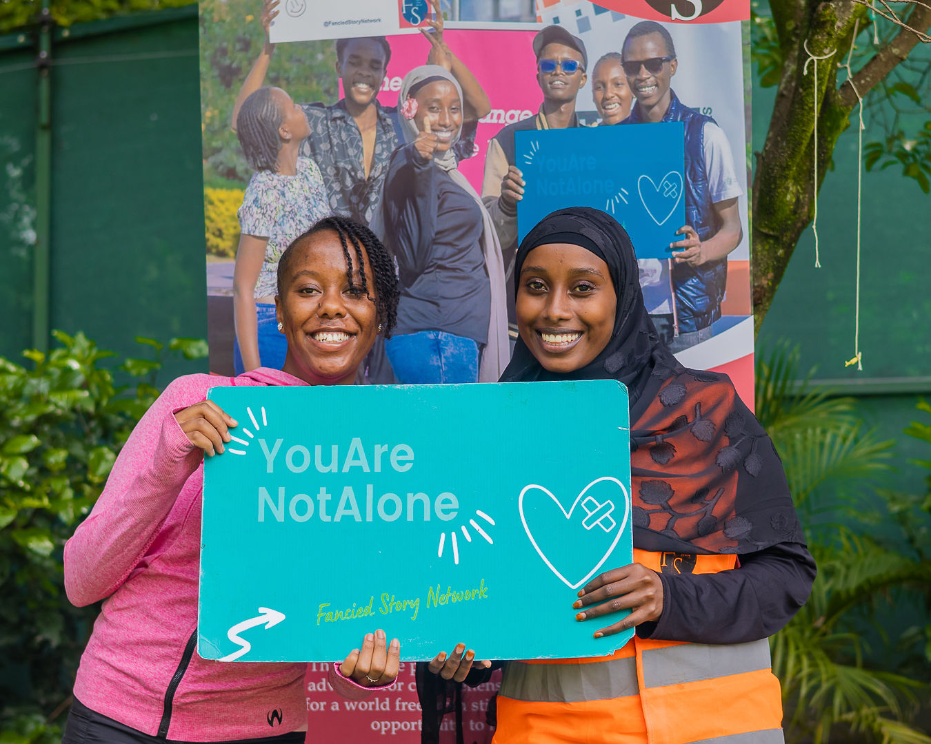 Two FSN community members holding YouAreNotAlone sign